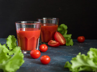Healthy food. Traditional Spanish cold gazpacho soup with ripe tomatoes or fresh tomato juice in glasses on a dark background
