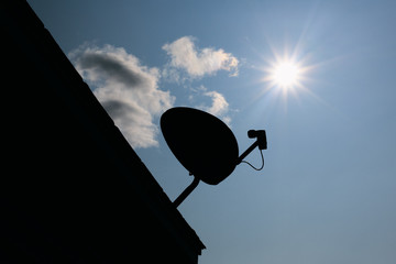 Wireless satellite dish silhouette and Sun.
