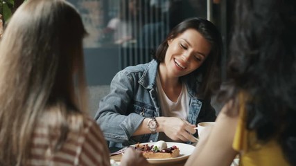 Young women are eating desserts and drinking coffee in cafe talking having fun enjoying leisure time and meeting with friends. People and happiness concept. - Powered by Adobe