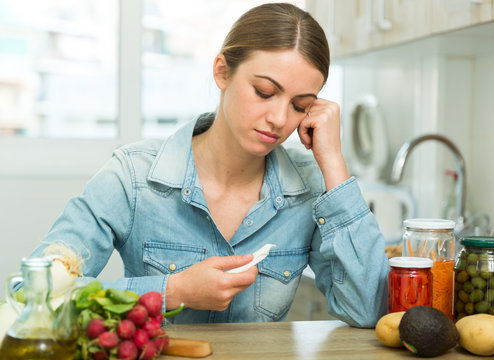 Woman suffering from headache at kitchen