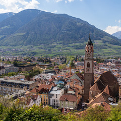 Skyline of main District of City Meran with Church, Vegetation and Mountains. Merano in spring. Province Bolzano, South Tyrol, Italy. Europe.