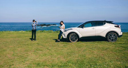 Young couple traveling by car making a stop to photograph the landscape