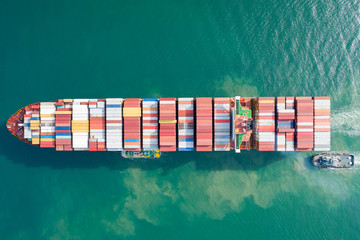 Fototapeta premium Aerial view and top view. Container ship in pier with crane bridge carries out export and import business in the open sea. Logistics and transportation