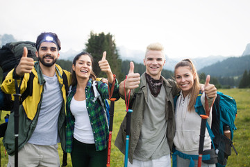 Group of friends on a mountain. Men and women climbing rocks.