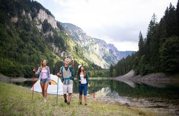 Smiling friends walking with backpacks. Adventure, travel, tourism, hike and people concept.