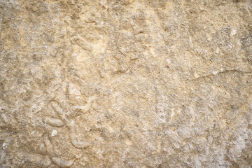 Stone surface. Beautiful background texture sandstone stone. The surface of the stone has a pleasant warm shade of light orange yellow-brown color with many large and small irregularities.