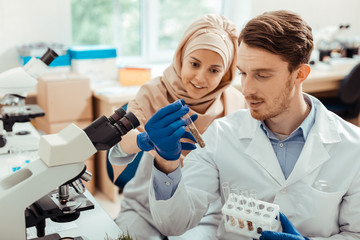Naklejka premium Handsome bearded man looking at the test tube with seeds