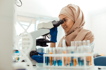 Positive muslim woman being at work in the lab