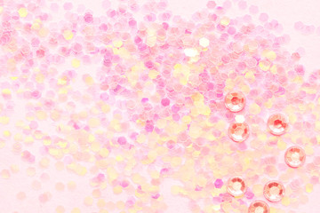 Confetti on pink paper background, festive concept.