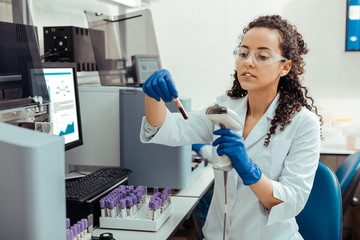Serious smart female researcher studying human DNA