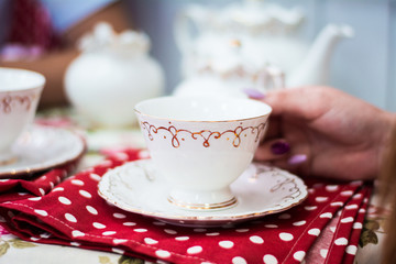 Cups teapot tea at the table red tablecloth in white peas interior design