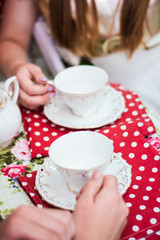 Cups teapot tea at the table red tablecloth in white peas interior design