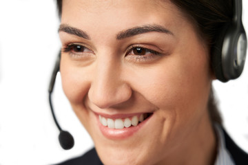 Close Up Of Businesswoman Wearing Telephone Headset In Customer Services Department