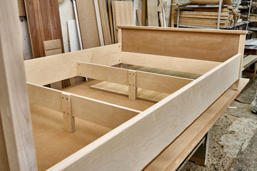 Bed building process. Wooden furniture manufacturing process. Furniture manufacture. Close-up