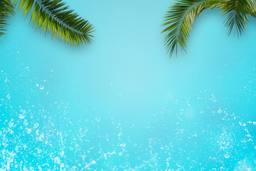 Fototapeta na wymiar rahmen aus isolierten palmenblättern und wassertropfen auf türkisem Hintergrund, tropischer strand abstrakt, konzept für kosmetik, reisen, spa