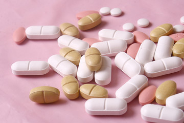Different pills on pink background