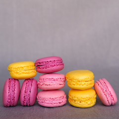 Assorted colorful delicious french macarons on gray background. Sweet food and pastry. Copy space
