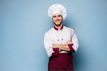 Portrait of smiling chef on light blue background