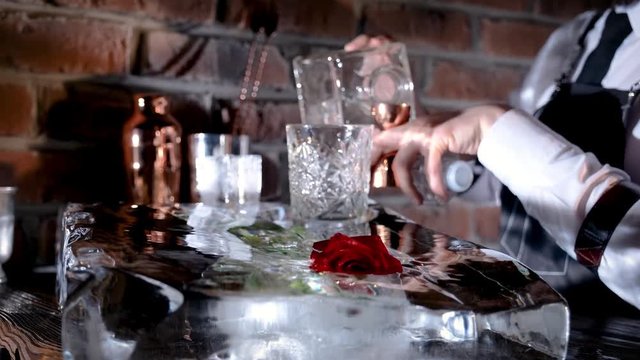 Classic bartender garnishing a negroni cocktail with a orange peel for serving in interior classy bar. Medium close up shot on 4k camera.