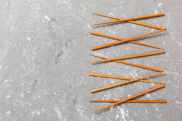 Many bamboo chopsticks on black cement stone background, top view with copy space. a lot of sushi sticks in the form of an ornament