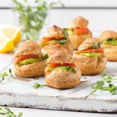 Snack cakes profiteroles with green pea cream and salmon red fish. Exquisite appetizer, tasty lunch, traditional food