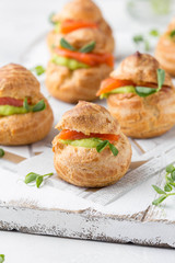 Snack cakes profiteroles with green pea cream and salmon red fish. Exquisite appetizer, tasty lunch, traditional food