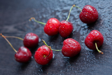 Ripe cherries on a dark wooden background