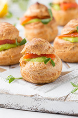 Snack cakes profiteroles with green pea cream and salmon red fish. Exquisite appetizer, tasty lunch, traditional food