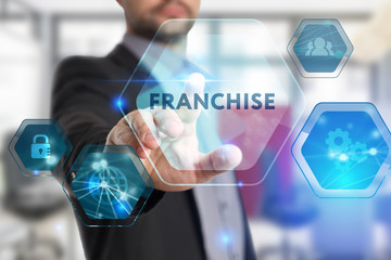 The concept of business, technology, the Internet and the network. A young entrepreneur working on a virtual screen of the future and sees the inscription: Franchise