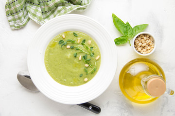 Vegetable green cream soup of peas, spinach, broccoli with pine nuts. Healthy lunch, delicate delicious food