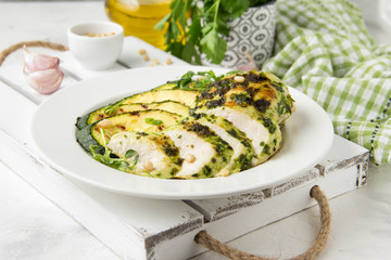 Grilled chicken fillet with green herb marinade, with slices of fried zucchini and pine nuts, healthy lunch