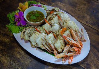 Crab meat with sauce in a dish on a brown table