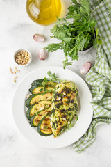 Grilled chicken fillet with green herb marinade, with slices of fried zucchini and pine nuts, healthy lunch