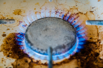 Obraz na płótnie Canvas gas burner.blue flame.dirty kitchen stove