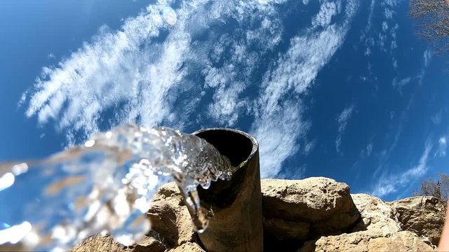 Natural mineral mountain source water pipe pour down over camera, super slow motion