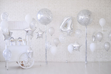 A lot of balloons silver and white colors. 