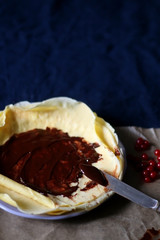 Homemade crepes with chocolate spread and red currants. Selective focus.