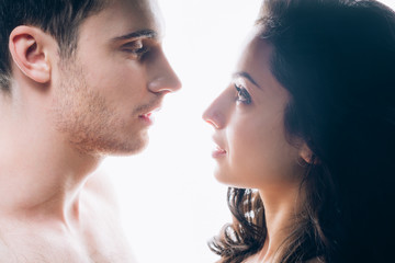 naked young couple looking at each other isolated on white