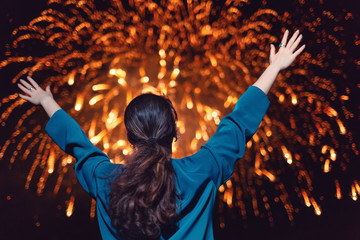 The woman enjoys the fireworks. The view from the back