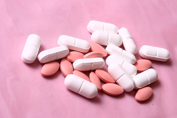 white and pink pills on pink background
