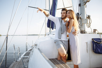 Beautiful couple walking on a yacht sailing on a river