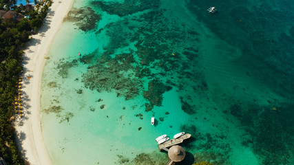Travel concept: sandy beach and hotels near the blue lagoon, from above, Boracay, Philippines. Seascape with beach on tropical island. Summer and travel vacation concept.