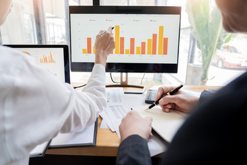 two young businessmen partner explaining information and pointing at report data discussing strategy agreement or contract at office, Teamwork, cooperation.