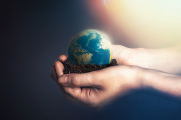 Women's hands holding soil with a globe of the planet Earth.The concept of environmental...
