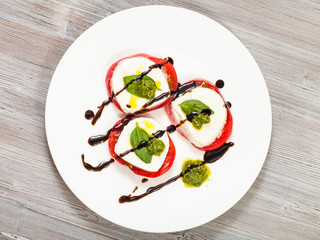 top view of mozzarella, tomato, basil with pesto