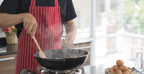 Cropped view of man prepare cooking food in black pan