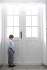elegant baby near a large white door