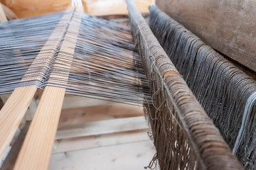 Old loom. The production of fabrics on an ancient machine. Close-up.