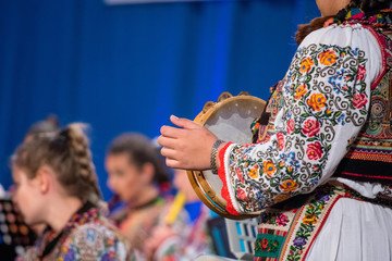 Close up of hands of young Romanian girl in traditional folkloric costume. Folklore of Romania