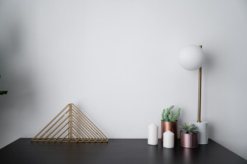 Composition of gold bookshelf and copper vase and gold stylish table lamp in mid century modern...